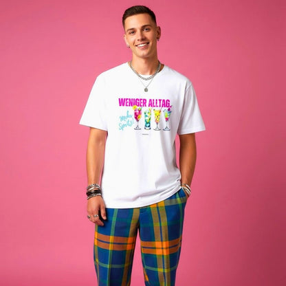     Weißes Statement-Shirt „Weniger Alltag. mehr Spritz!“ mit Cocktail-Motiv vor pinkem Hintergrund an männlichem Model.