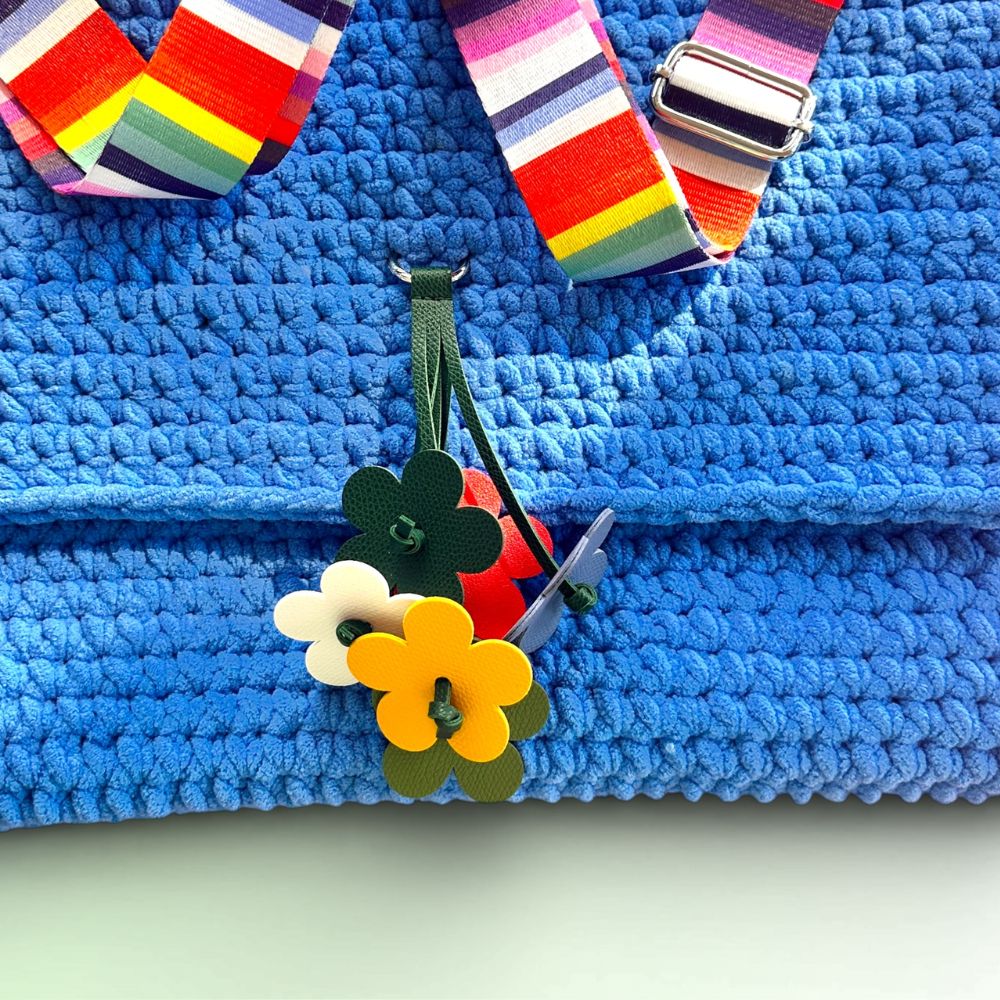 Detailaufnahme der Häkeltasche Blue Bloom #154 mit Lederblumen-Charm und gehäkelter Struktur
