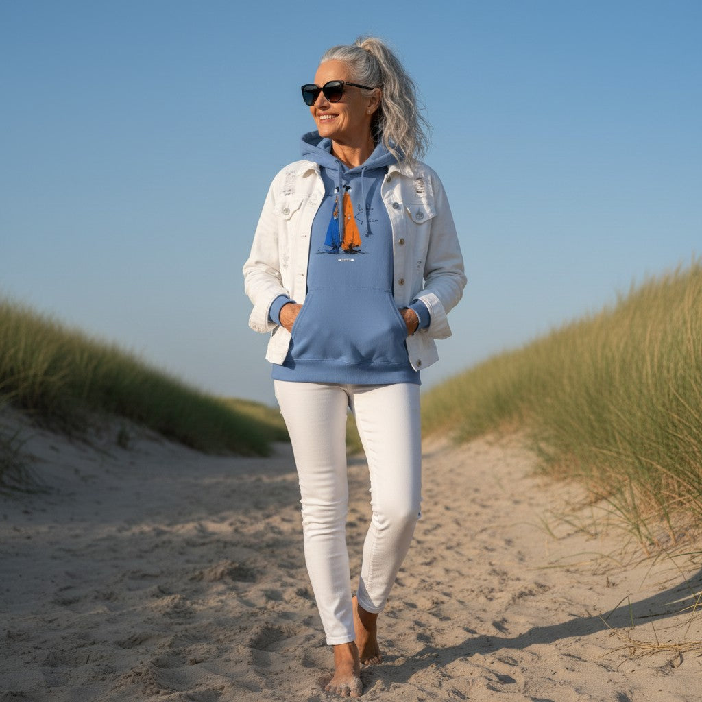 Frau trägt Carolina Blue HOOKamSEE Hoodie Karma kennt beide Seiten in den Dünen