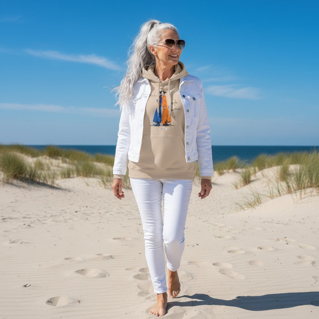 Frau trägt sandfarbenen HOOKamSEE Hoodie Karma kennt beide Seiten am Strand