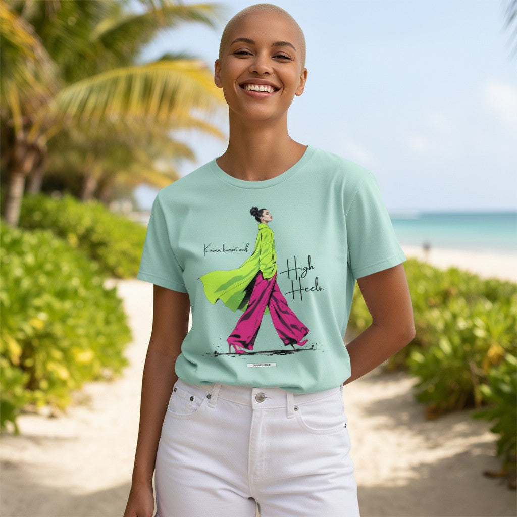 Frau trägt mintgrünes Statement-Shirt Karma kommt auf High Heels von HOOKamSEE am Strand