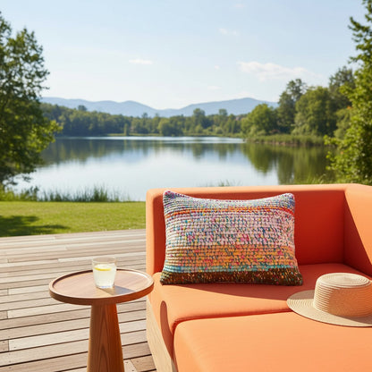 Kissen Meadow Confetti auf einem orangefarbenen Outdoor-Sofa mit Seeblick