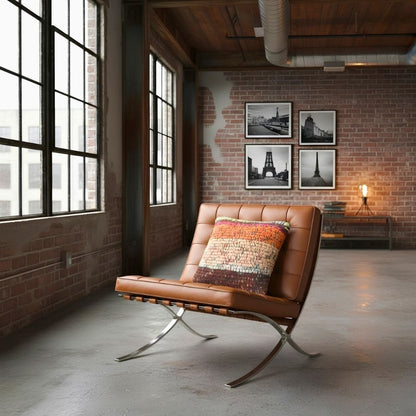 Kissen Rust Blossom auf cognacfarbenem Loungesessel in einem Loft mit Backsteinwand