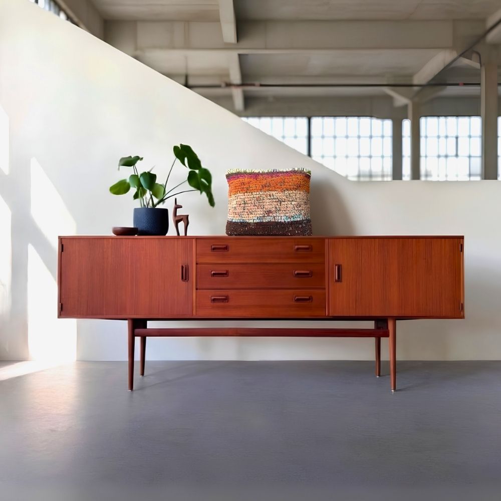 Kissen Rust Blossom auf einem Midcentury-Sideboard aus Teakholz mit Grünpflanze