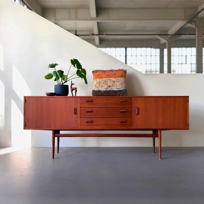 Kissen Rust Blossom auf einem Midcentury-Sideboard aus Teakholz mit Grünpflanze