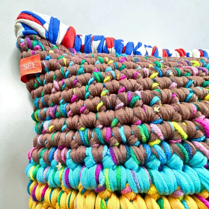 Detailaufnahme der Coiled-Crochet-Struktur von Kissen Saffron Clay in Taupe-Braun, Türkis und Ocker-Gelb mit sichtbarem HOOKamSEE-Label