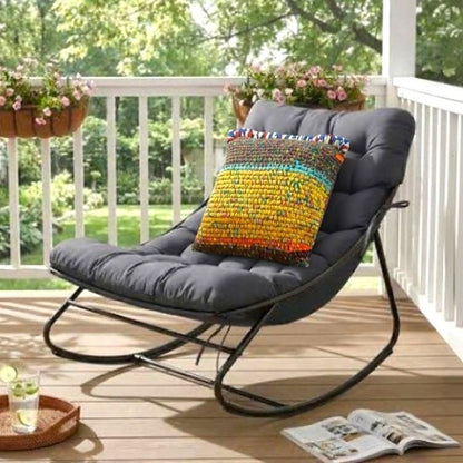 Kissen Saffron Clay auf einer schwarzen Outdoor-Loungeliege auf einer Holzterrasse