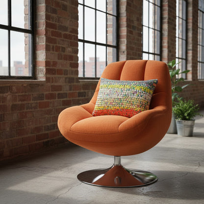 Kissen Sundown Grey auf orangefarbenem Loungesessel in Industrieloft mit Backsteinwänden