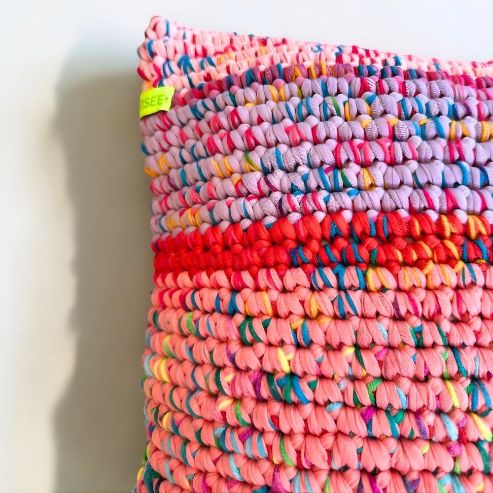 Nahaufnahme der reliefartigen Häkelstruktur des Kissens Sunset Bloom mit HOOKamSEE Schriftzug