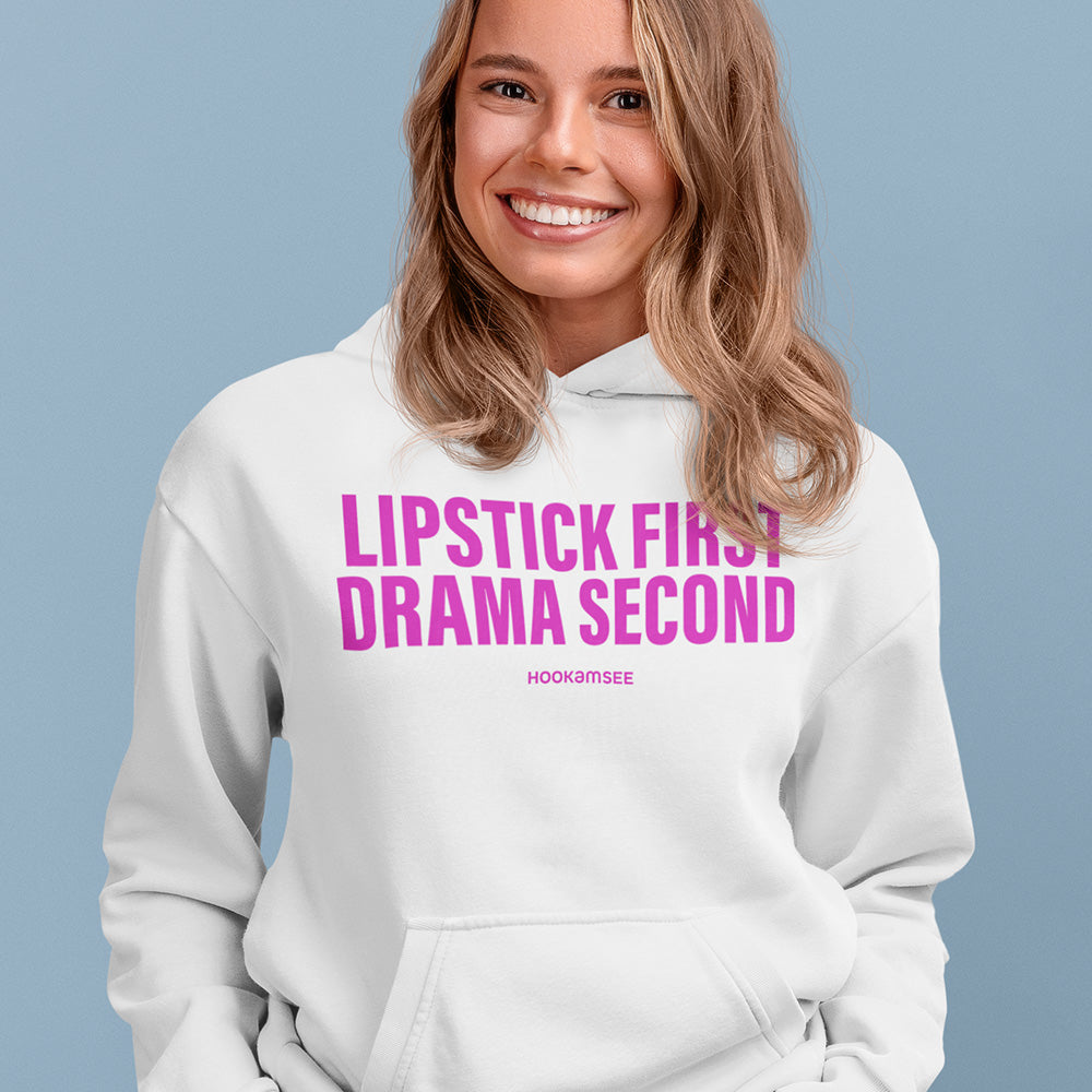 Frau trägt weißen Unisex Hoodie mit pinkem Statement „LIPSTICK FIRST DRAMA SECOND“ von HOOKamSEE
